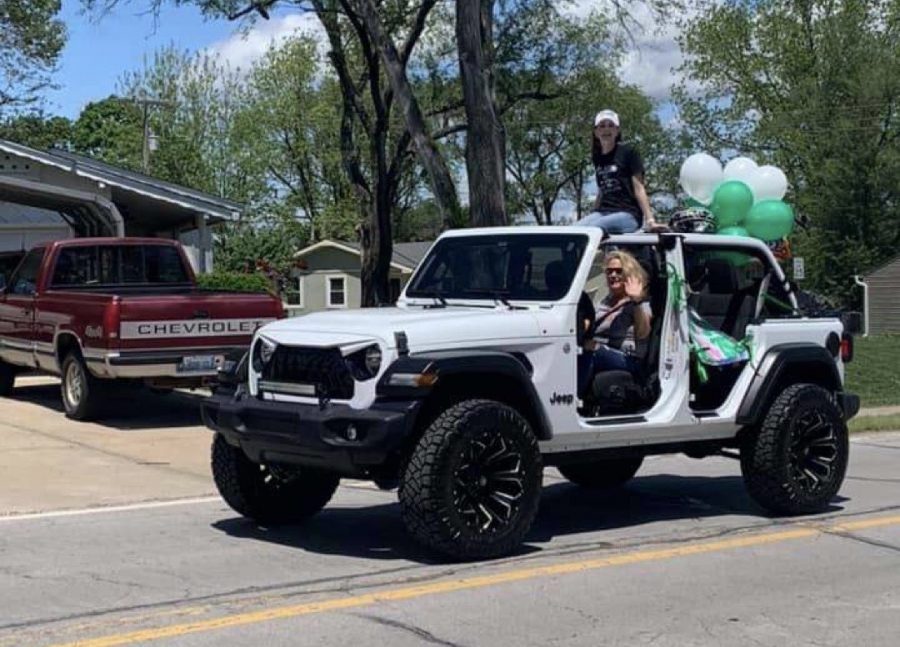 Senior Mason Johannes rides through celebratory graduation parade with her mom and dad on Sunday, May 17.