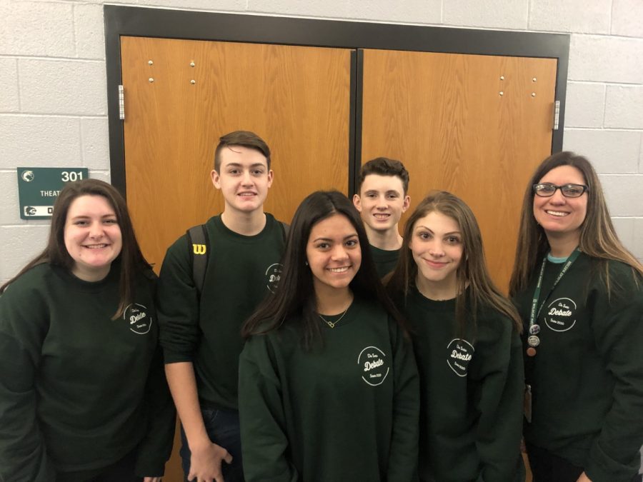 Inga Kelly poses with junior debate State qualifiers Hunter Finerty, Blake Hinson, Brooke Cobos, Natalie Nusz and Ryan Handley before leaving for the State competition on Jan. 17-18 at Hutchinson High School.
