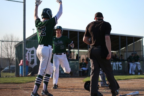 Junior Weston Madden congratulates senior Luke Millman on running into home base on April 1, 2019.  