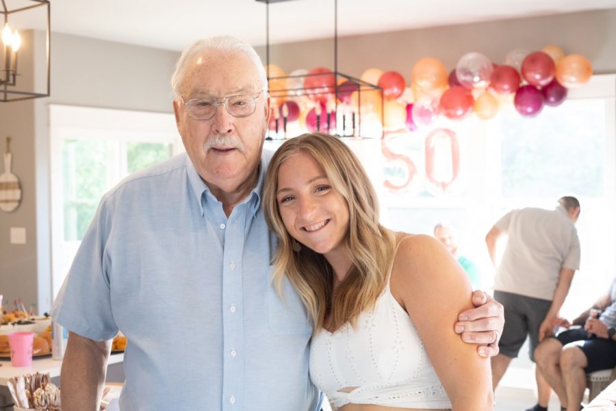 Former substitute teacher, GeralsCulver, stands with his granddaughter and DHS alumnus Maggie Kroeger at a family celebration.