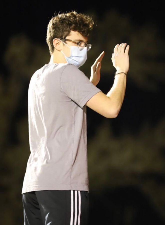 Junior Kendan Powers conducts the DHS Band during a performance at a DHS football game. 