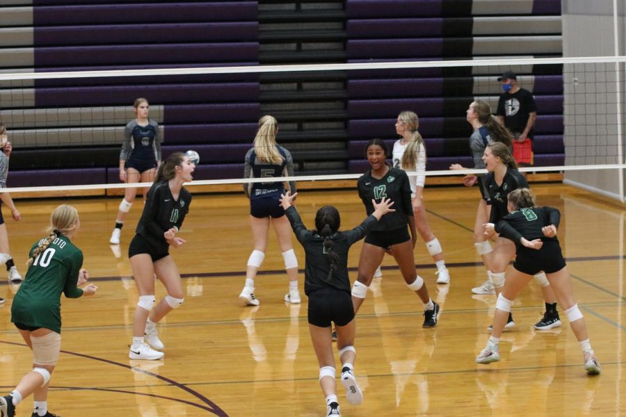 The varsity volleyball team celebrates after gaining a point against Louisburg on Sept. 3.