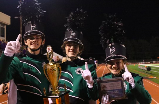 Drum majors Kendan Powers, Ryan Handley and Emma Klingler pose for a picture with the Grand Champion trophy at Baker University on Oct. 13. 