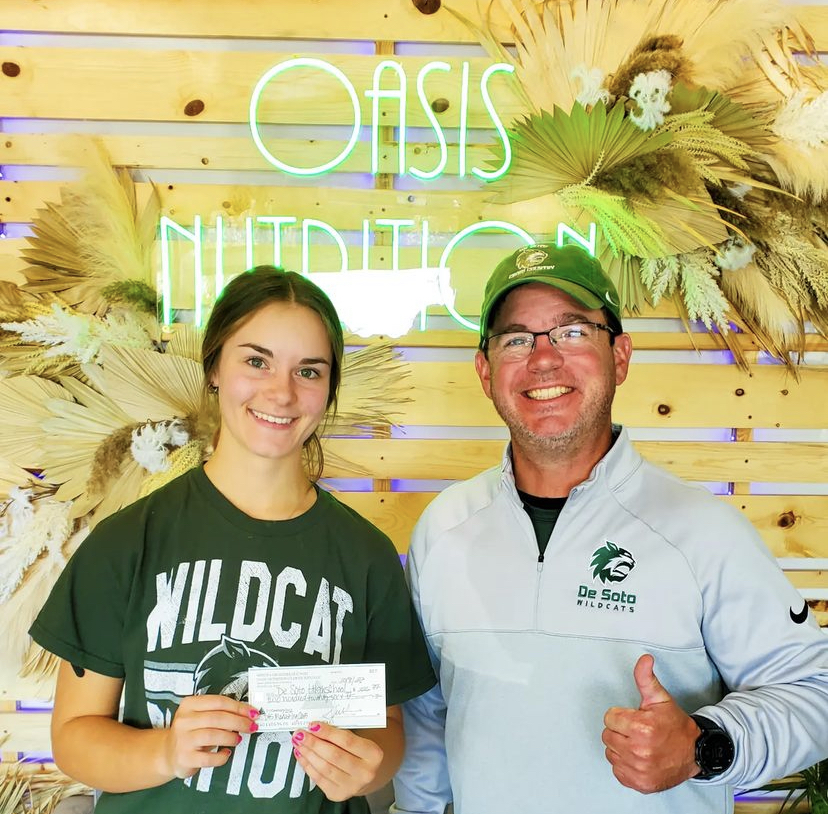 Junior Ivy Stoltz and Marketing teacher Ben Stamey pose with the money they earned during the fundraiser.