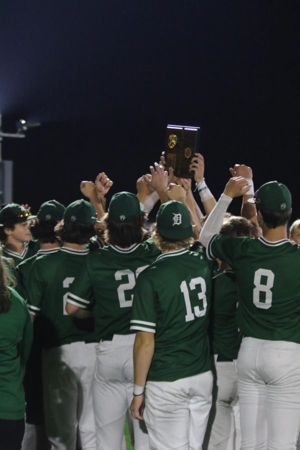 The team calls it a night as they huddle around the trophy one last time before the state tournament.