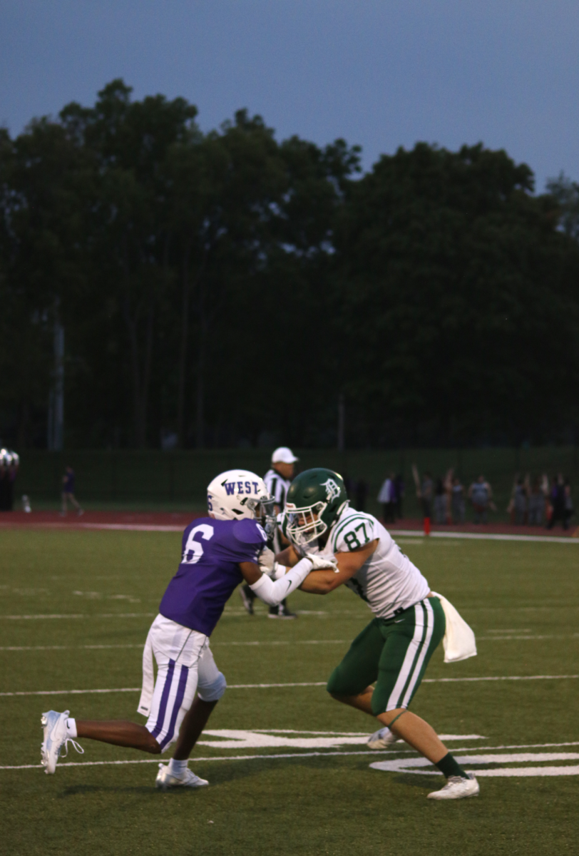 Providing coverage, senior Peyton Hughes stops his opponent.
